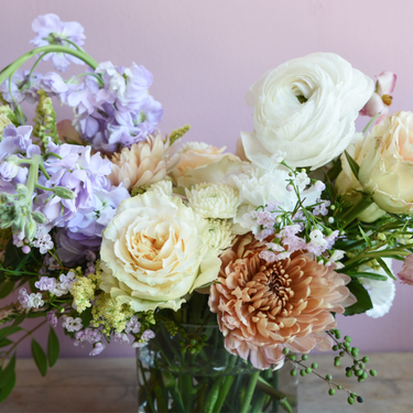 A beautiful flower arrangement in soft and romantic hues. This bouquet features white ranunculus, peach roses, lavender stock, and caramel-colored chrysanthemums, creating a delicate and airy feel. Perfect for birthdays, anniversaries, or to celebrate a new baby. Available for local delivery in Wake Forest, NC.